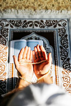 Close up of praying hands. 
Religious man doing muslim prayer on prayer mat in a mosque