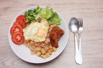 Fried rice with tomato sauce Or as we call it American fried rice Served with fried eggs, fried chicken, fresh stir-fry, and fried bread.
