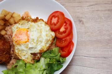 Fried rice with tomato sauce Or as we call it American fried rice Served with fried eggs, fried chicken, fresh stir-fry, and fried bread.