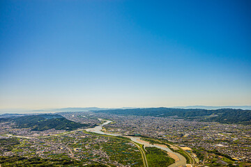 梅雨晴れの中、紀の川上空を飛ぶパラグライダーから撮影。和歌山市街と和歌山湾