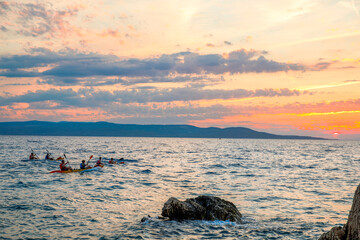 Kayaker paddling the kayak at sunset sea. Kayaking, canoe, paddling. Amazing beach sunset with...
