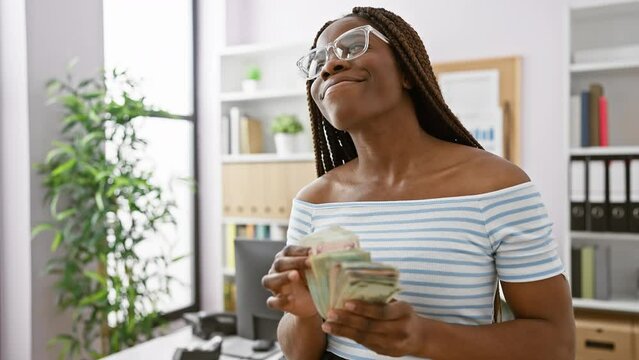Confident woman entrepreneur counting dirhams in a modern office setup