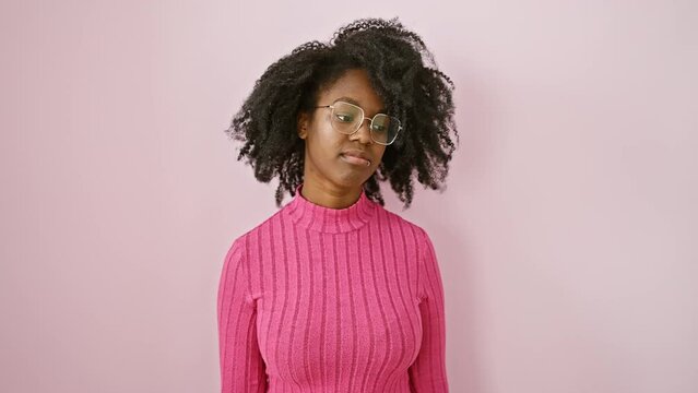 Cheeky african american woman wearing glasses, standing with outrageous attitude, shows middle finger in a hilarious 'fuck you' gesture, reflecting rude and provocative expression