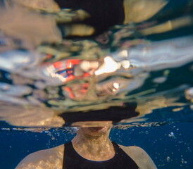Neck and shoulders of a woman snorkeling in the ocean.
