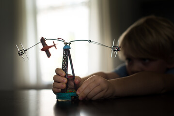 Child playing with a retro miniature vintage airplane toy