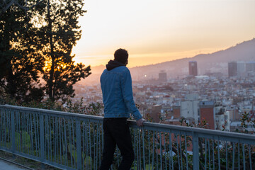 Guy looking at the sunset, enjoy beautiful city view, traveler mock up top of the city
