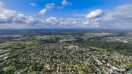 aerial panorama Ukrainian rural country side scenic view of village living houses and green environment space around with far horizontal landscape and cloudscape in summer clear weather day time