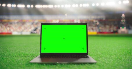 Laptop Computer with a Green Screen Mock Up Display with a Soccer Ball Rolling in the Background on a Stadium Field at Night. Template for Software, Streaming, Sports Betting, Multimedia Content