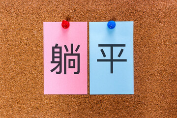 Chineses keyword Tang ping (躺平) on stickers attached to a cork board. The word means 