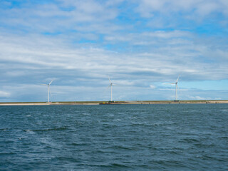 Rotterdam, Netherlands - August 4th 2024: Wind generators on a dame close to Europoort.