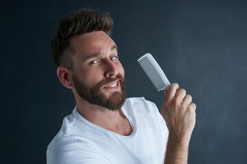 Man, portrait and comb in studio for grooming or haircare, self care and hairstyle for maintenance...