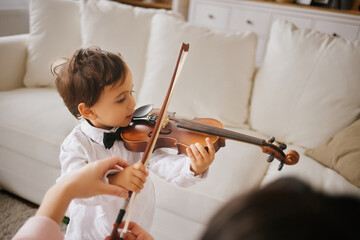 Little boy learning how to play violin 