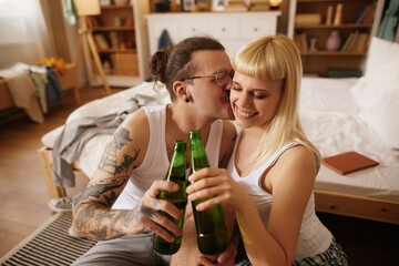 Caucasian couple drinking beer at home