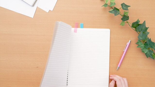 Girl opening a notebook. Class, classroom, desk, study, learning, homework, preparation, review, notes, business etc.　ノートを開く女の子。授業、教室、机、テーブル、学習、勉強、宿題、予習、復習、メモ、ビジネスなど
