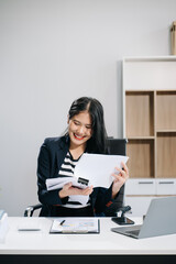 Asian businesswoman working in the office with working notepad, tablet and laptop documents