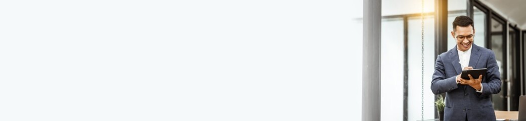 Middle-aged Asian businessman in formal suit working diligently at his desk. seasoned business and investment consultant, specializing in strategic portfolio management and financial analysis.