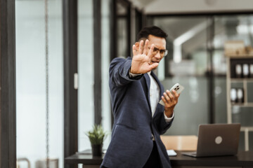 Middle-aged Asian businessman in formal suit working diligently at his desk. seasoned business and investment consultant, specializing in strategic portfolio management and financial analysis.