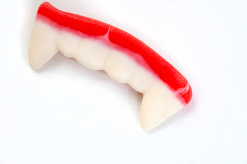 Single Dracula or vampire teeth gummy isolated on white