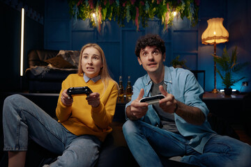 Young couple playing video game using joysticks together