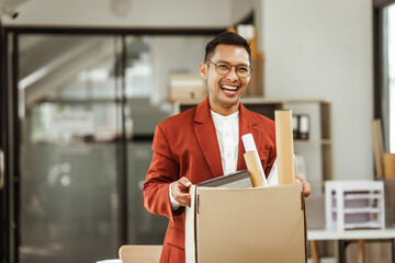 A middle-aged Asian businessman in a formal suit is working at his desk, preparing to resign after...