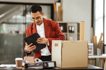 A middle-aged Asian businessman in a formal suit is working at his desk, preparing to resign after...