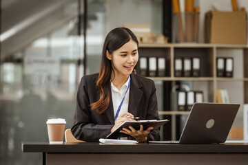 A young Asian businesswoman is seen diligently working at her desk. She's immersed in tasks ranging from recruitment and onboarding to performance management and diversity initiatives.