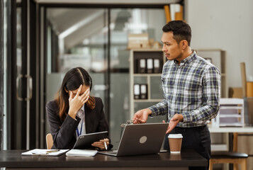 Young businesswoman and other Asian individuals are seen working at desks. Accountability, faultfinding, negligence, and other aspects of recruitment, staffing, and talent management being discussed.