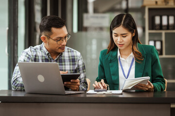 A middle-aged businessman, a young businesswoman, and Asian individuals are collaborating at desks. They engage in teamwork while managing commodities, trade, finance, and talent acquisition.