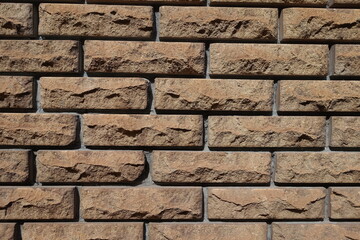 Front view of brown split face brick veneer wall with stretcher bond pattern