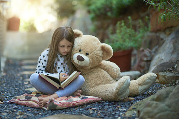 Outdoor, teddy bear and child with book for reading, education and language development. Backyard,...