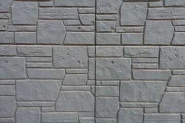 Texture of dark gray concrete brick veneer wall with random layout