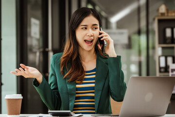 Young woman and other Asian individuals in formal suits working at desks with laptops. They engage in financial tasks including amortization, liquidity analysis, risk assessment, financial modeling.