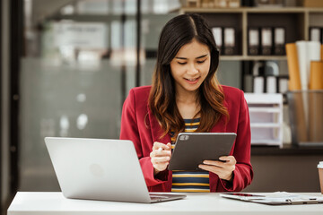 A young woman and other Asian individuals in formal suits are seen working at desks with laptops, portraying a successful and happy demeanor.