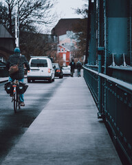 Moody image of a cyclist riding on a bridge in Germany on a rainy day