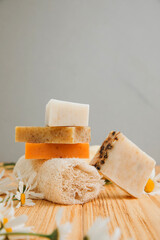 Handmade soap from natural ingredients, various herbs, chamomile. Concept of sustainable use, bath products on a wooden background. Front view