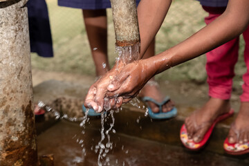 Children washing their hands at an outdoor water tap. Keep your hands clean. current affairs 2020....