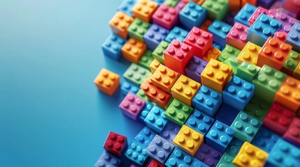 A pile of colorful building blocks stacked creatively on a plain surface, with open space on the left for text placement.
