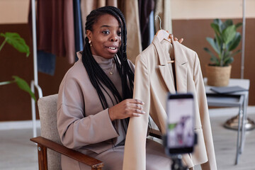 Portrait of Black young woman as fashion consultant recording video for social media