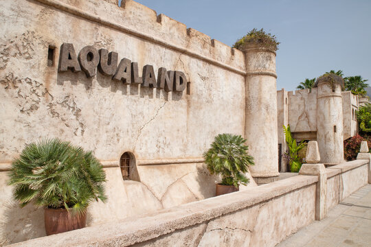 Aqualand, Costa Adeje, Tenerife, Canary Islands, Spain - March 17, 2024: exterior of the popular water park resembling an ancient, weathered fortress with big stone walls that appear cracked and aged