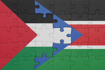 puzzle with the colourful national flag of south sudan and flag of palestine.
