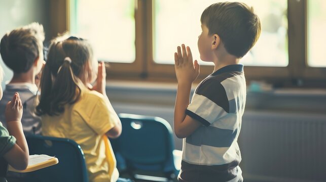 Children in a classroom praying with hands clasped, showcasing innocence and the essence of childhood faith and education.