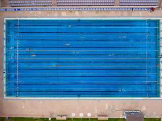 group of swimmers training in an outdoor pool top down view