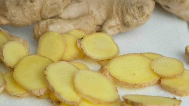 Slices of fresh ginger root falling, slow motion.