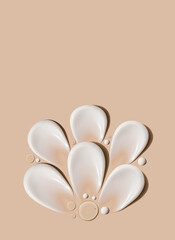composition of brush strokes of creamy texture of cosmetic samples on a pastel beige background