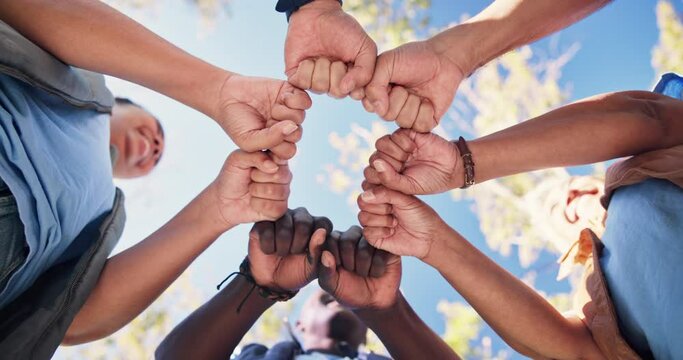 People, fist and hands in circle in outdoor for support or community program, solidarity and diversity with unity for synergy. Teamwork, huddle and together for volunteer for park or garden cleanup.