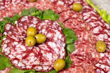 Thinly sliced smoked salami sausage with cilantro and olives