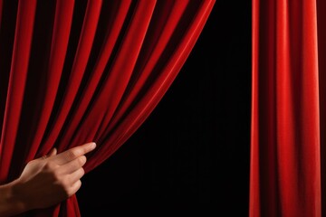 A hand opening red curtain backgrounds textile pattern.