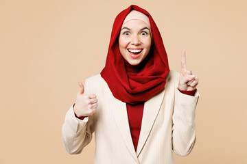Young Arabian Asian Muslim woman wear red abaya hijab suit clothes hold index finger up with great...
