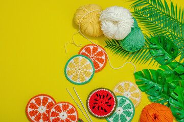 Handmade summer background. Slices of crocheted fruits, traditional accessory, bright yellow color