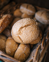 Assortment of Freshly Baked Sesame Seed Buns in a Rustic Basket